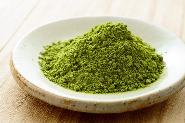 白い皿に盛られた緑色の国産抹茶の粉末