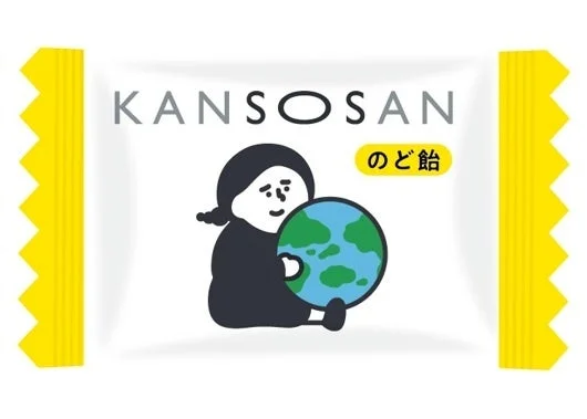 KANSOSANのど飴の個包装。白地に黄色の縁取りと地球を抱くキャラクターが描かれています。