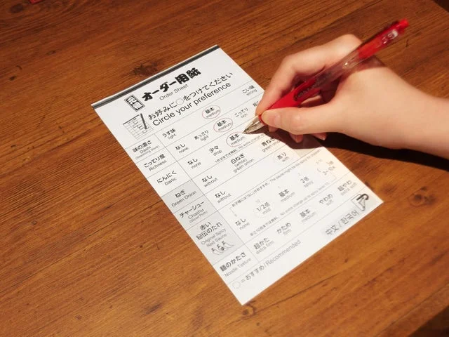 一蘭のオーダー用紙に記入している手元