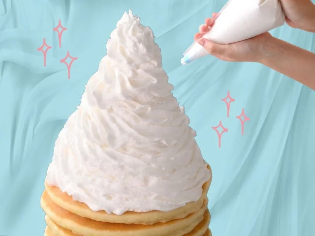 パンケーキにホイップクリームを絞り出している様子