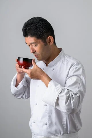 お吸い物の香りを確かめる料理人の姿