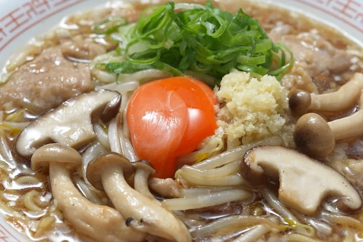 玉子、椎茸、しめじ、刻み生姜、ネギが乗った醤油ラーメン