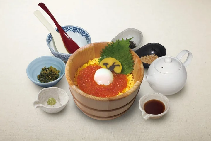 いくら、温泉卵、うさぎのかまぼこを添えた木製容器の月見おひつごはん