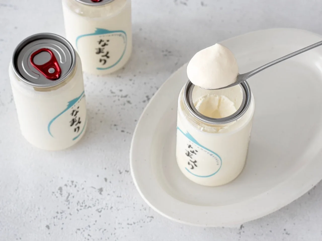 なまくりの白い缶と、スプーンで掬った白いクリーム