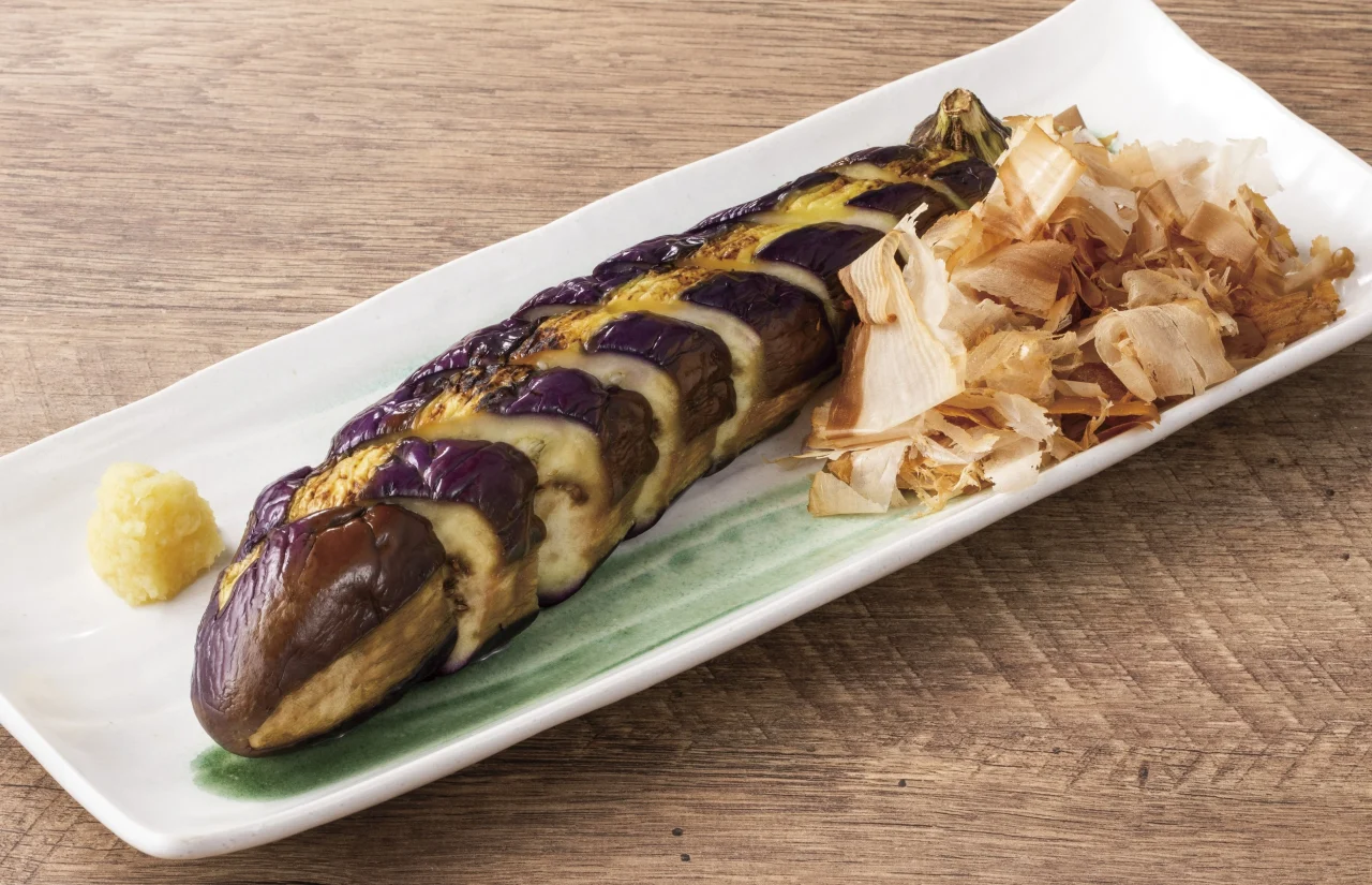 丸ごと一本秋なす焼き。焼き茄子と削り節、薬味を添えた皿
