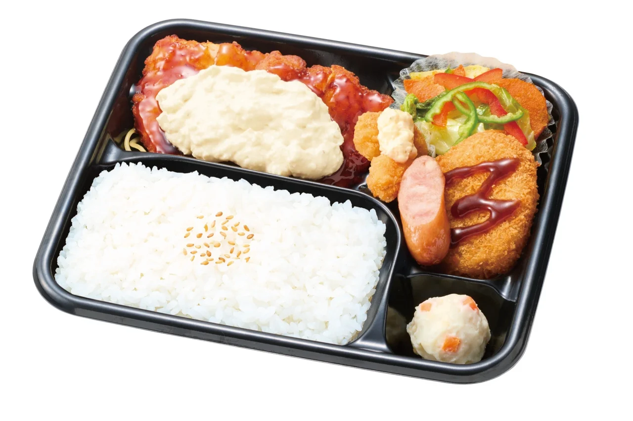 チキン南蛮スペシャル。黒い弁当箱に、タルタルソースと黒酢あんのかかったチキン南蛮、コロッケ、ウインナ
