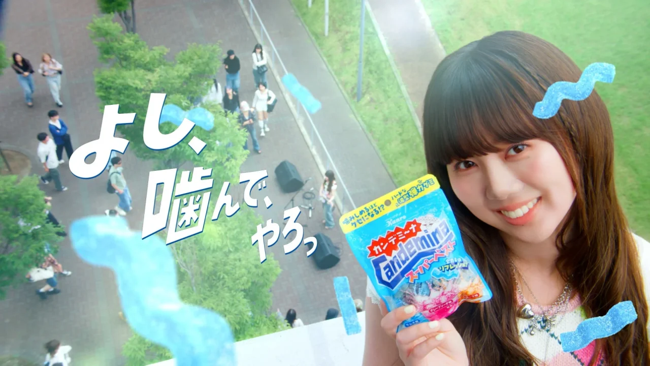 カンデミーナグミ新WEB CMのビジュアル。ふみのさんがパッケージを持ち、キャッチコピー「よし、噛んで、やろっ」が描かれている。