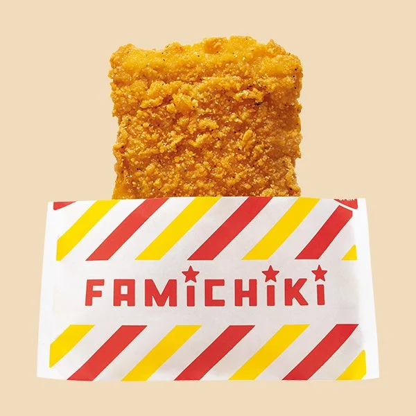 ファミチキの衣付き鶏肉が、赤と黄色の斜線模様の紙袋に入っている様子