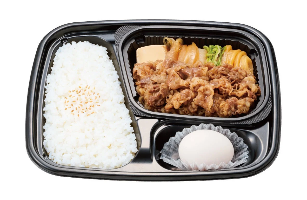 牛すき焼弁当 肉倍盛。黒い容器に牛肉と野菜、ご飯、生卵が入った弁当