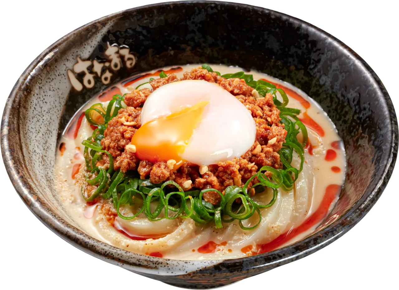 温玉ごま担々うどん。黒い丼にうどん、挽き肉、半熟卵、ネギが乗っている