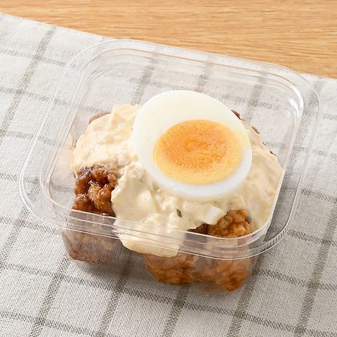 透明な容器に入ったタルタルソースがかかったチキン南蛮