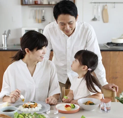 食卓を囲む親子三人の笑顔の様子