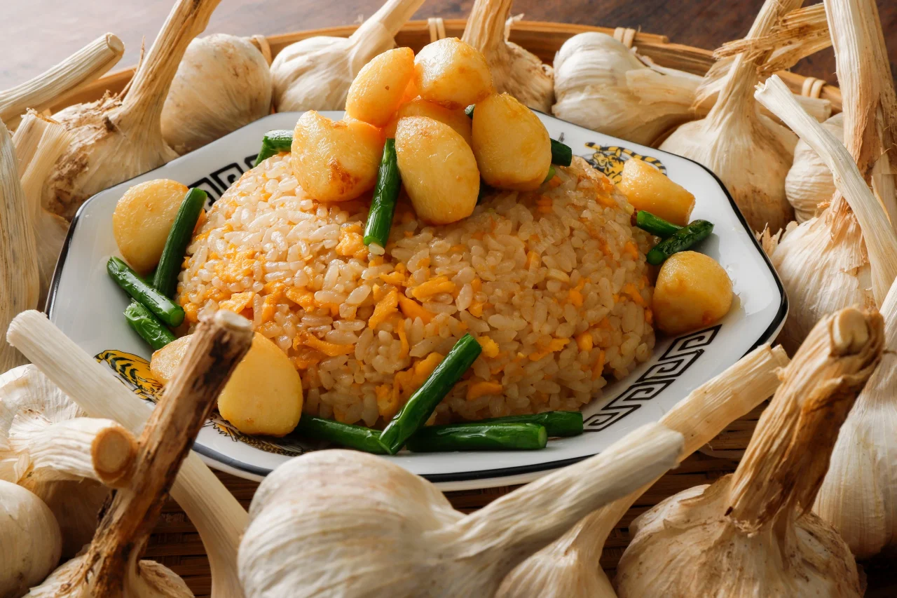 ニンニクチャーハン。卵とネギを混ぜたご飯にニンニクを添えた料理。