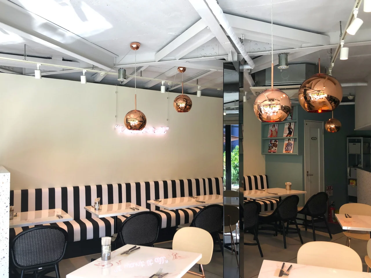 MICASADECO&CAFE なんばの店内。ストライプのソファ席と丸いペンダントライトが特徴。