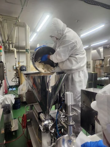 製造工場で作業服を着たスタッフがクリームを製造している様子