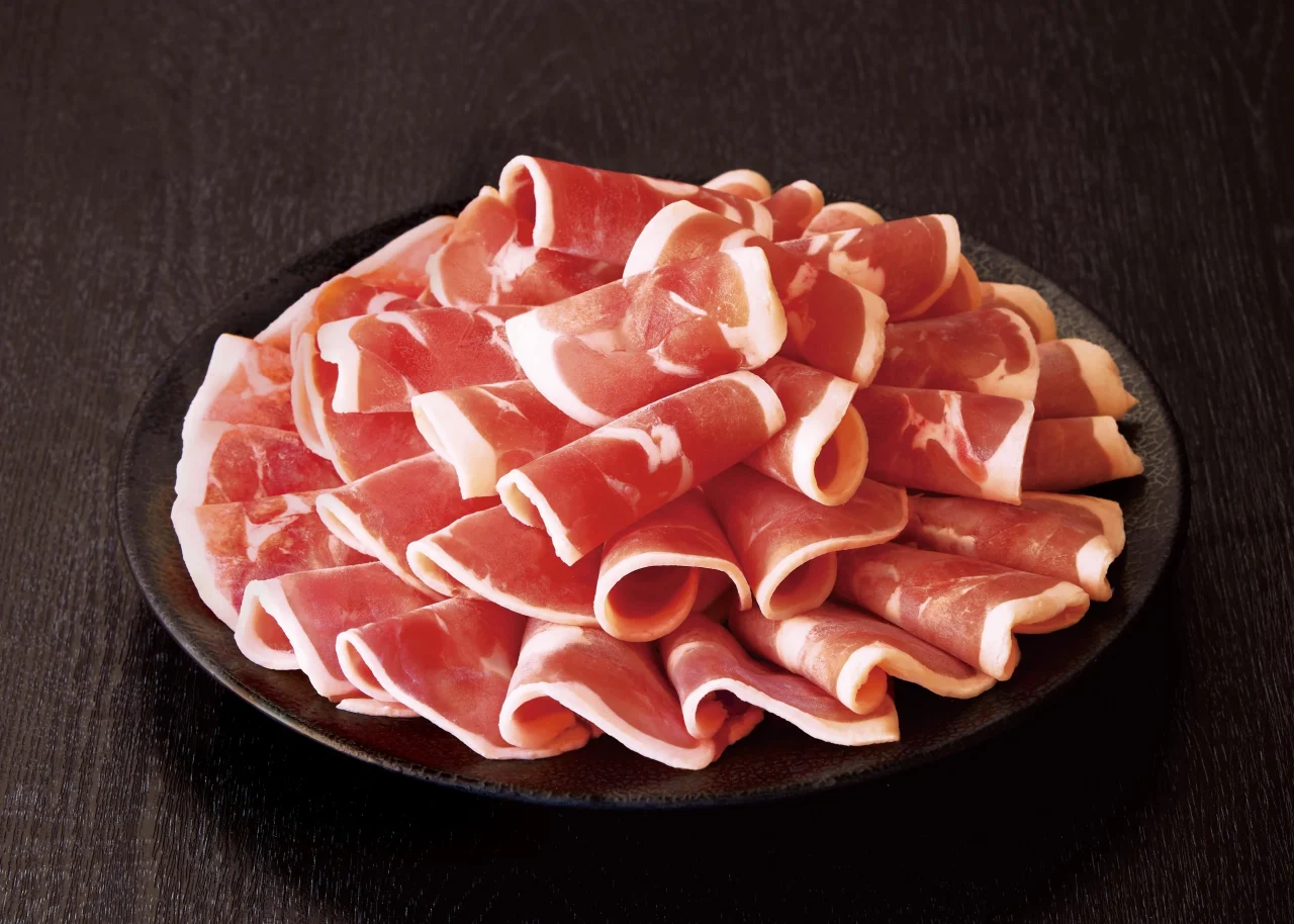 黒い皿に盛られた薄切りの豚肉