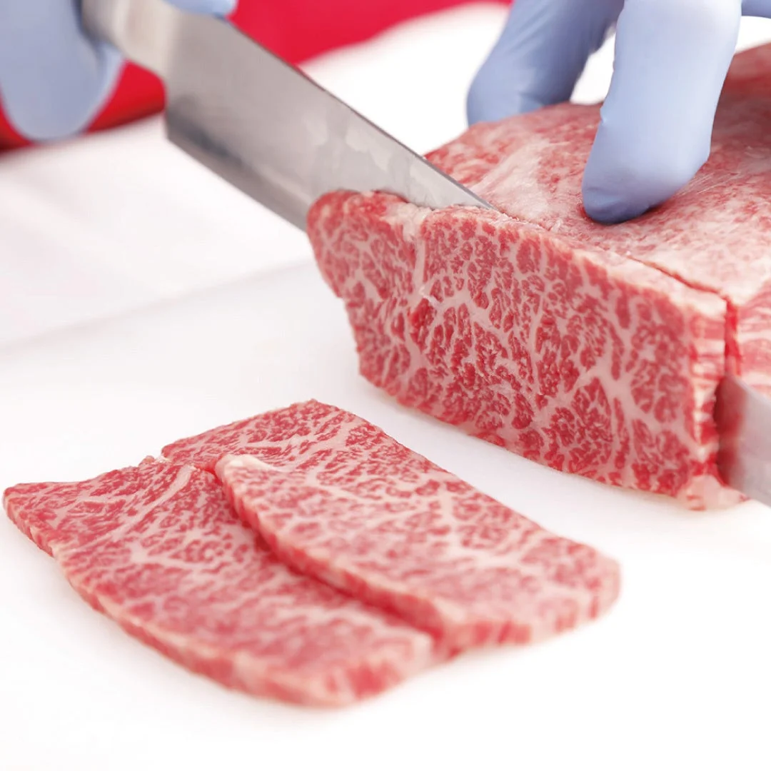 安楽亭の自然肉を包丁でカットする様子