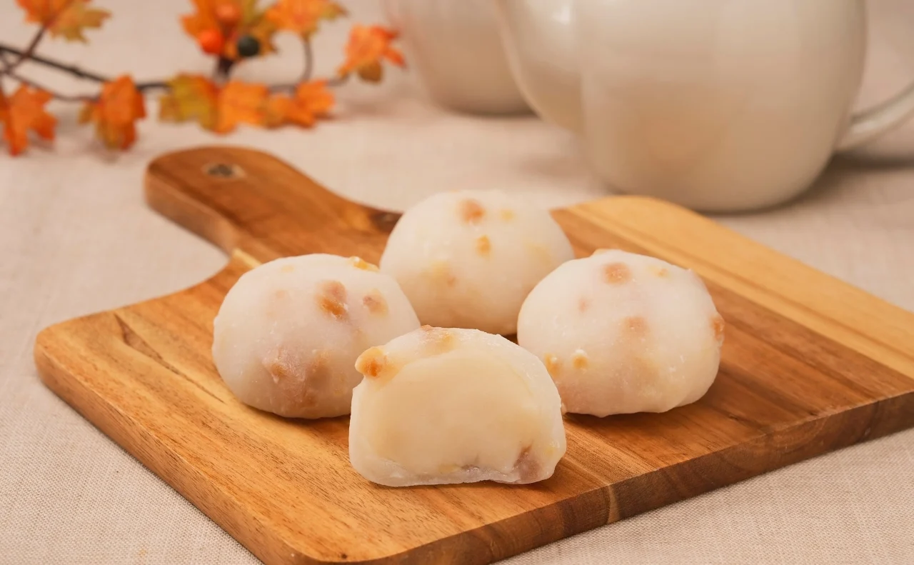 アーモンドミルク大福。木製トレイに並べた白い餅菓子で、表面にクラッシュアーモンドが見えます。