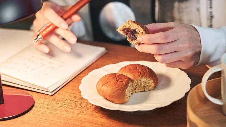 仕事中にデスクでBASE BREADこしあんを食べる様子