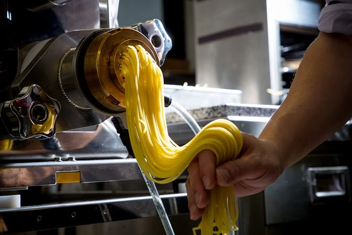 製麺機から出てくる生パスタを手に取る様子