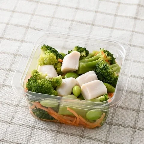 透明な容器に入ったブロッコリーや枝豆などの緑野菜サラダ