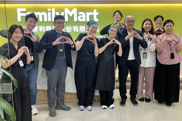 台湾ファミリーマートの店舗内で、右近氏ら関係者が心形ポーズで並ぶ集合写真