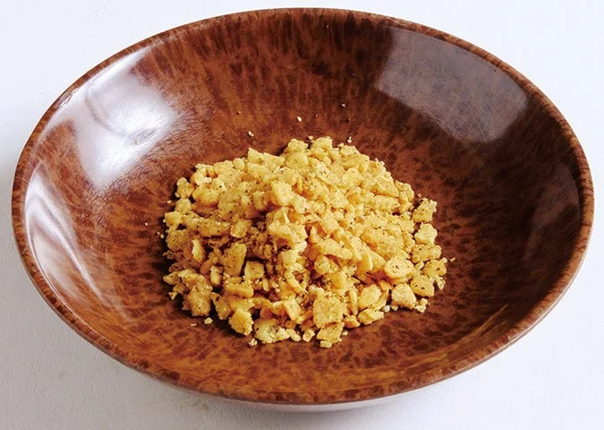 茶色の陶器の器に盛られた黄色いスパイシーガーリック調味料