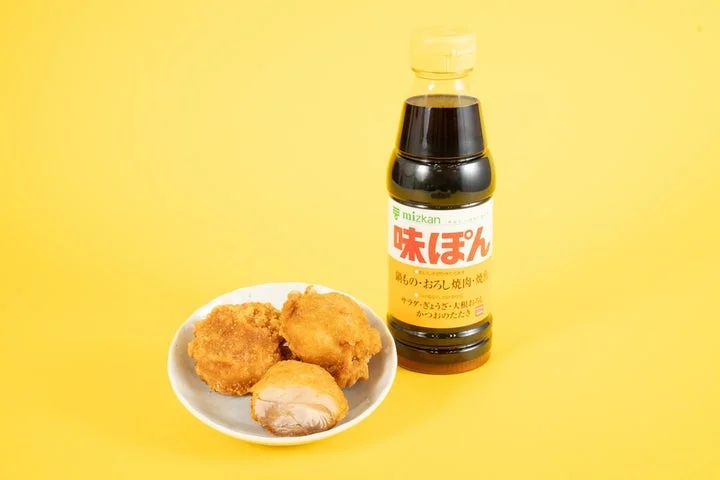 白い皿に盛られたファミからと、味ぽんのボトルを黄色い背景で撮影した商品写真