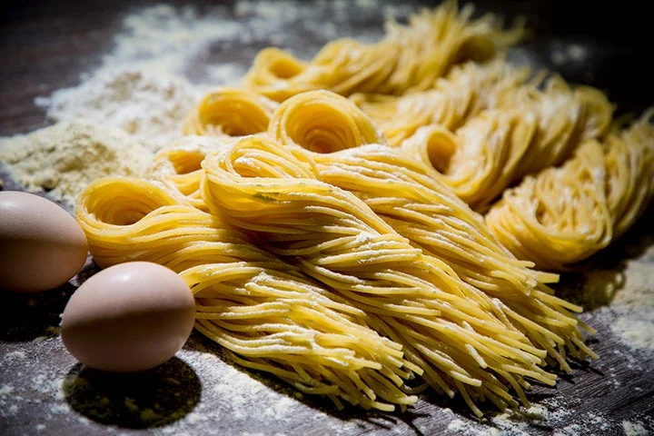 束ねられた生パスタと卵