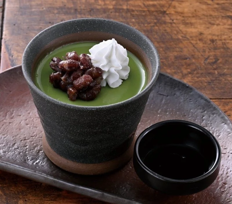 黒い器に盛られた抹茶プリンと添えられた小鉢