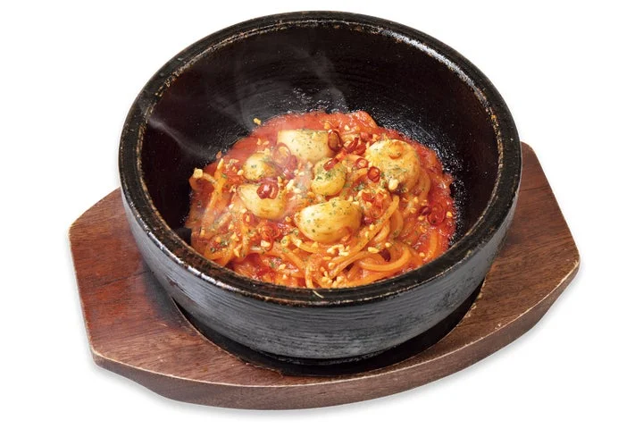 熱々の石焼で提供されるトマトとにんにくのスパゲッティ