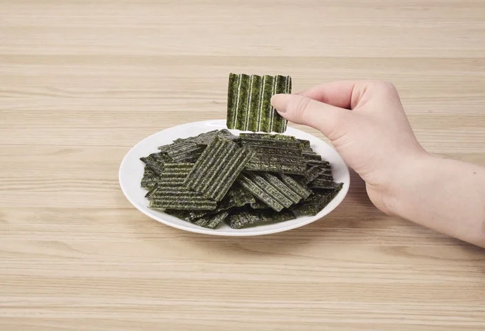 皿に盛られたザクのりチップスと、それを手でつまむ様子