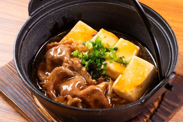 鉄鍋に入った黄金出汁の和牛あんかけすき焼き豆腐
