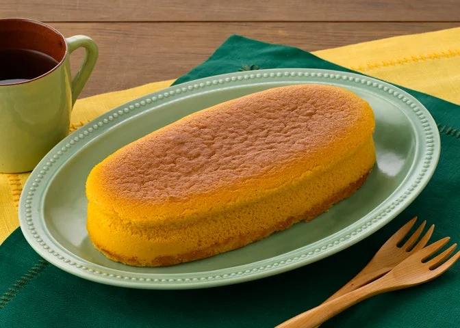 緑の楕円形プレートに盛られた黄色いチーズスフレケーキ