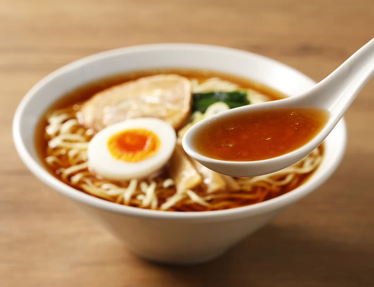 レンゲですくったマルちゃん正麺のスープと調理済みのラーメン