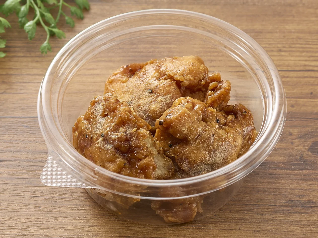 冷たいまま食べる甘辛鶏唐揚のイメージ画像。透明な容器に入った甘辛だれを絡めた唐揚げが写っている。