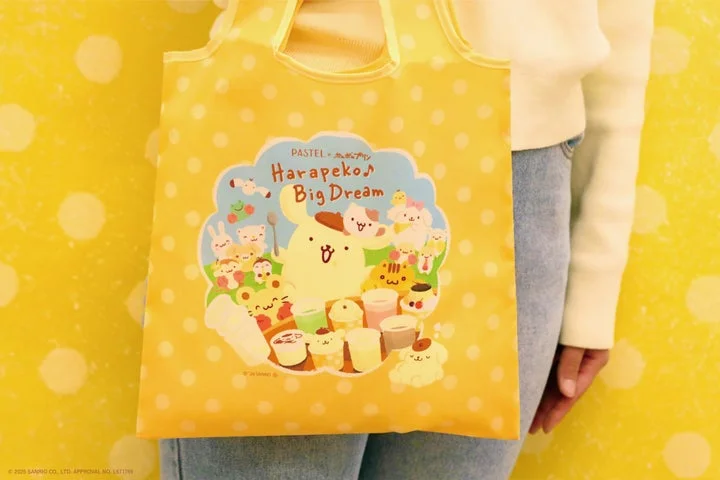ポムポムプリン柄のエコバッグを持つ手元