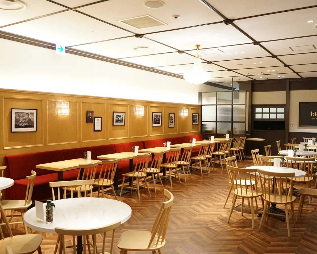 阪急うめだ店の店内。赤いソファと木製テーブル、椅子が並ぶカフェ空間。