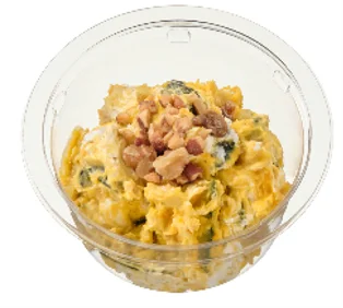 透明な容器に入った黄色いポテトサラダで、上にハムや野菜が乗っている