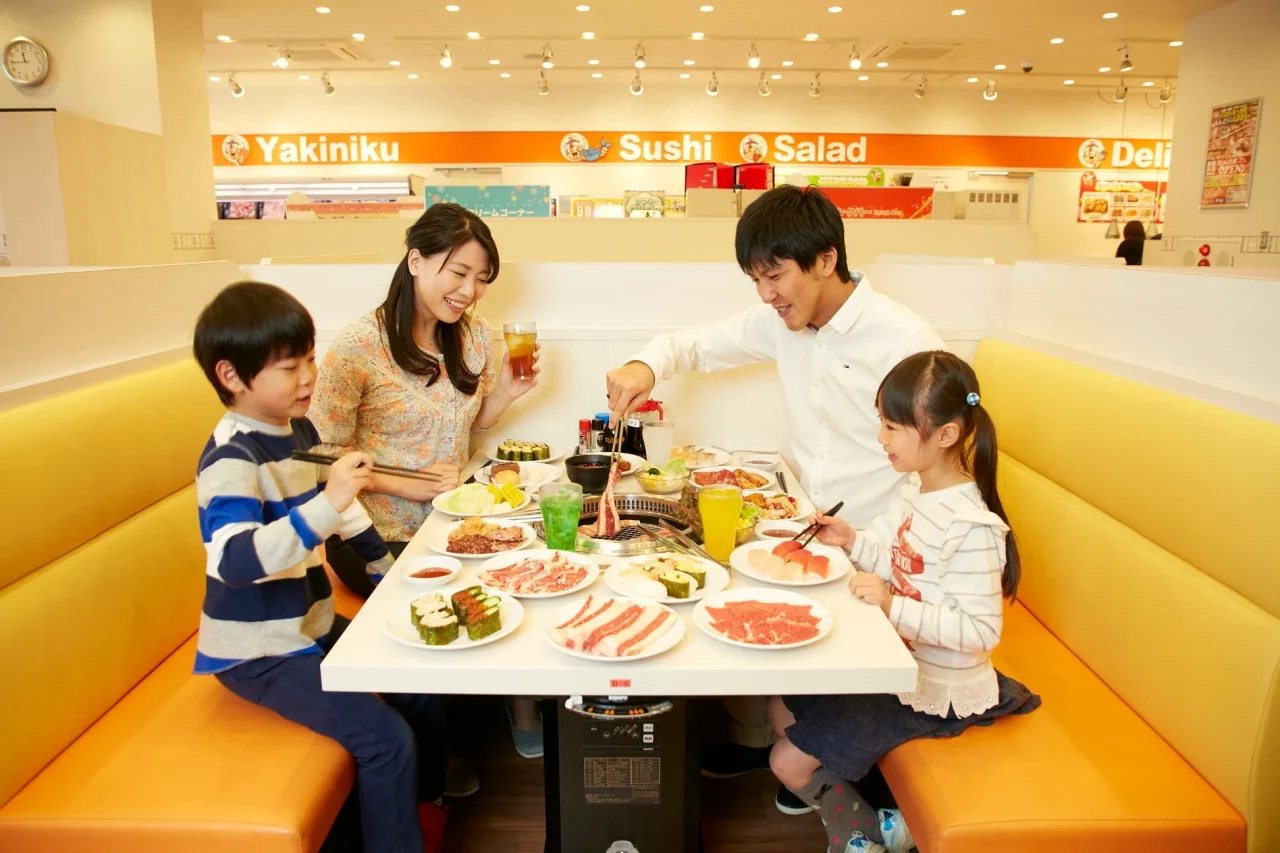 すたみな太郎の店内で家族が焼肉や寿司を食べる様子