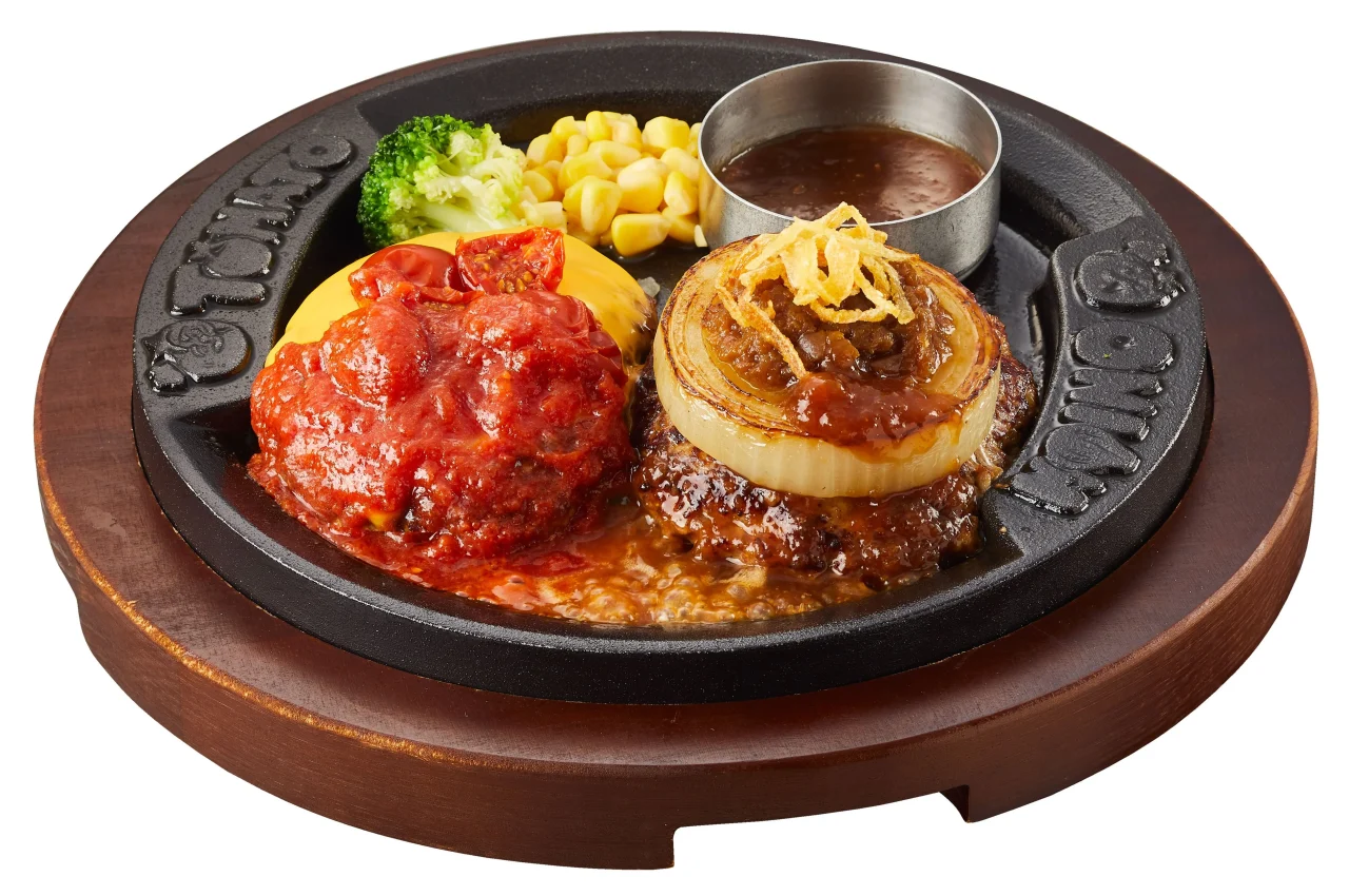 トマトアンドオニオンのツインハンバーグ。鉄板に2つのハンバーグと野菜を添えて提供。