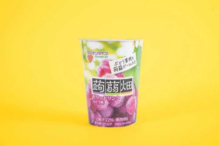 黄色い背景に置かれた蒟蒻畑ゼリードリンクぶどう味のパッケージ