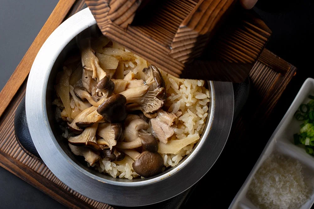 鶏とひらたけの秋香る釜めし。木蓋の釜からきのこや鶏肉がのったご飯が見える。