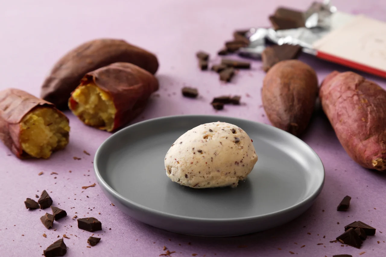 グレーの皿に盛られたチョコチップ入りのさつまいもジェラートと、周囲に配置されたさつまいも。
