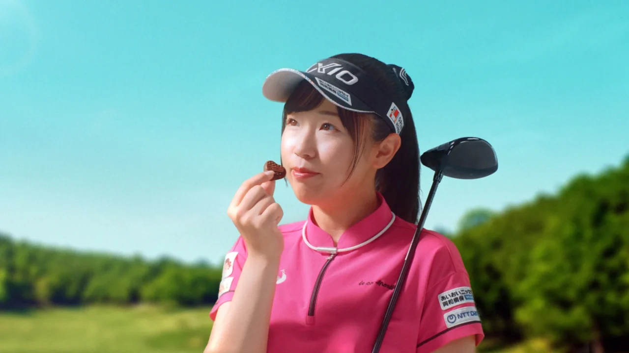 ピンクのゴルフウェアを着た女性がハート型チョコを手にするCMカット