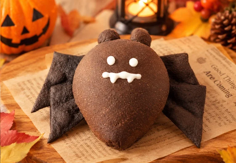 ハロウィンこうもりのチョコパン。白い顔のイラストと黒い羽が特徴。