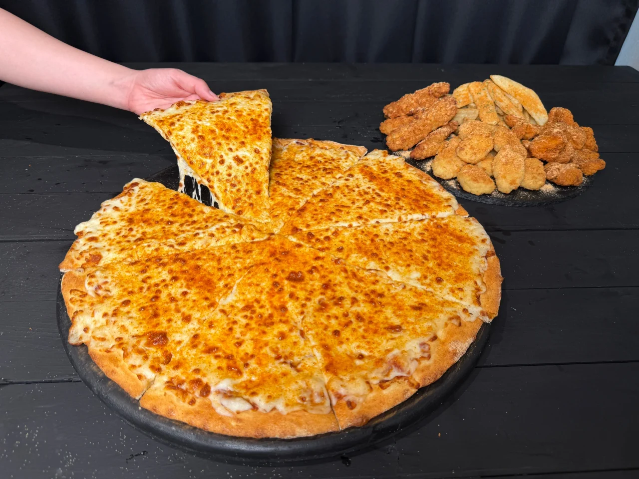チーズピザと4種のサイドメニューを並べたデカ盛り祭秋の陣の提供風景