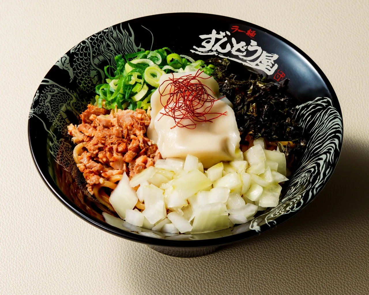 ラー麺ずんどう屋の麻辣まぜそば。黒い丼に麺、チャーシュー、水餃子、ネギ、海苔が乗っている。