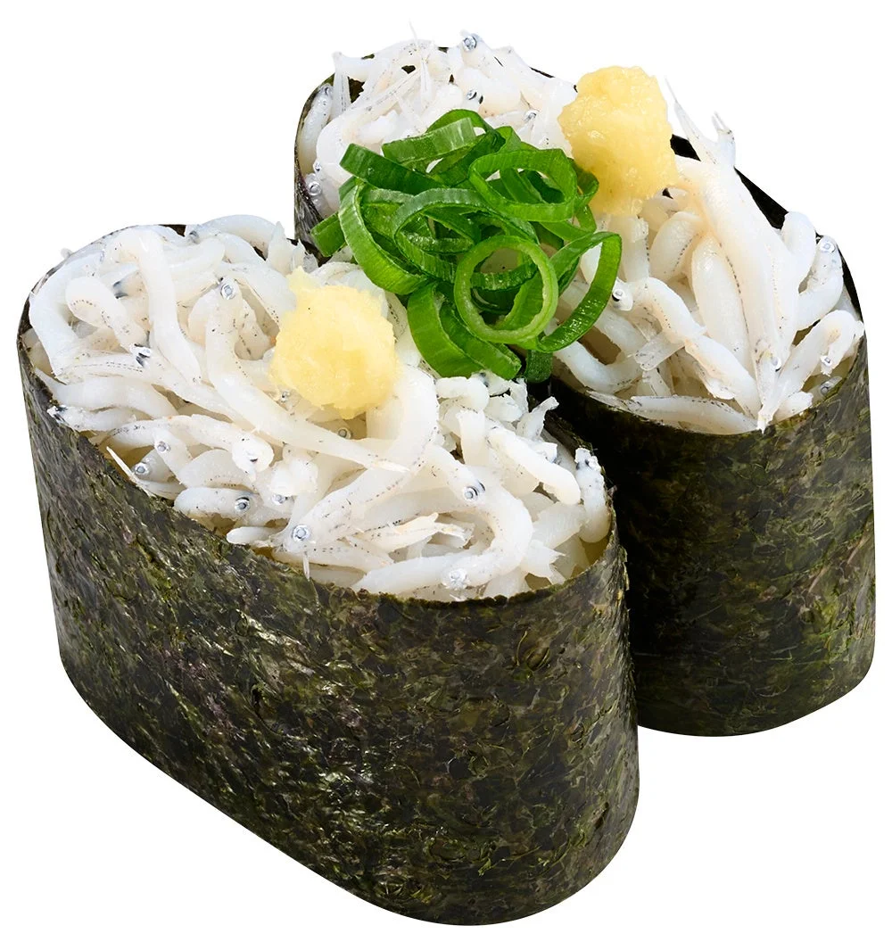 海苔で巻いた白い小魚の軍艦寿司2貫と、中央に盛られた緑色のネギと黄色い薬味