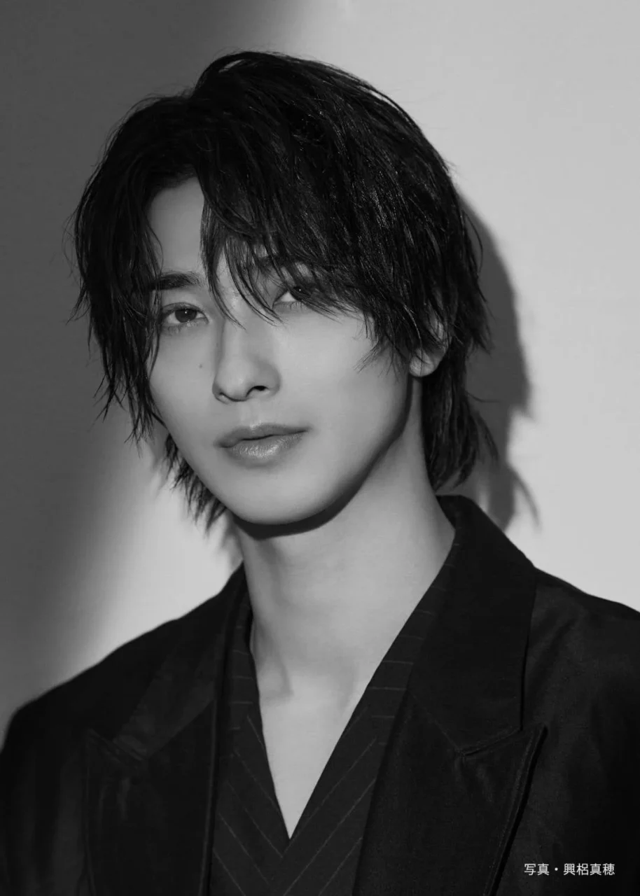 横浜 流星さんの黒白ポートレート。黒いスーツ姿でカメラを見つめている。